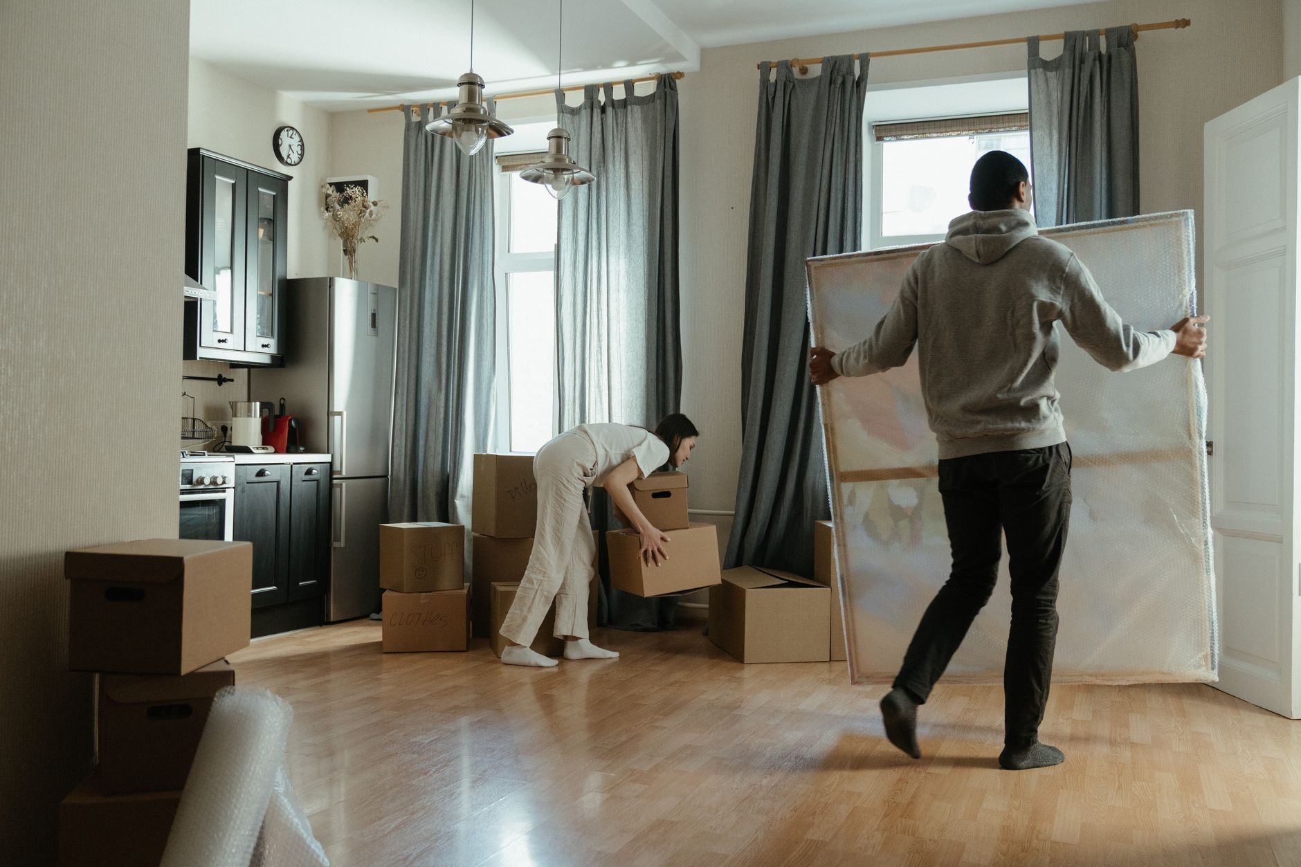 Couple packing moving boxes together in their living room ahead of a planned move