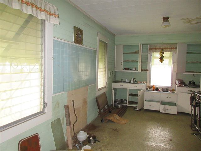 Dated kitchen with vintage cabinets in an as-is house