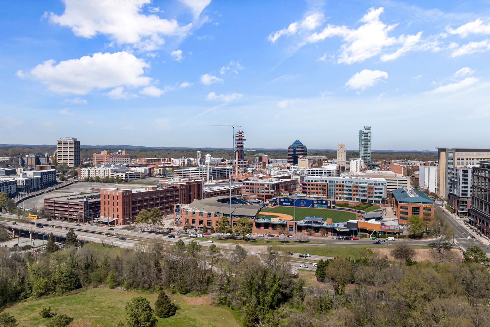 Aerial view of downtown Durham, NC with the Durham Bulls Athletic Park and city skyline