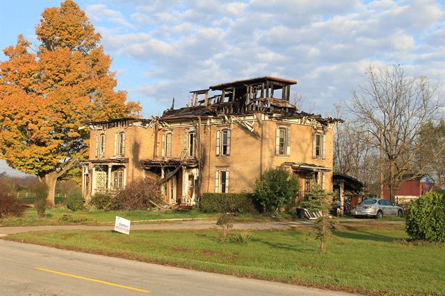 Brick house with severe fire damage to its roof