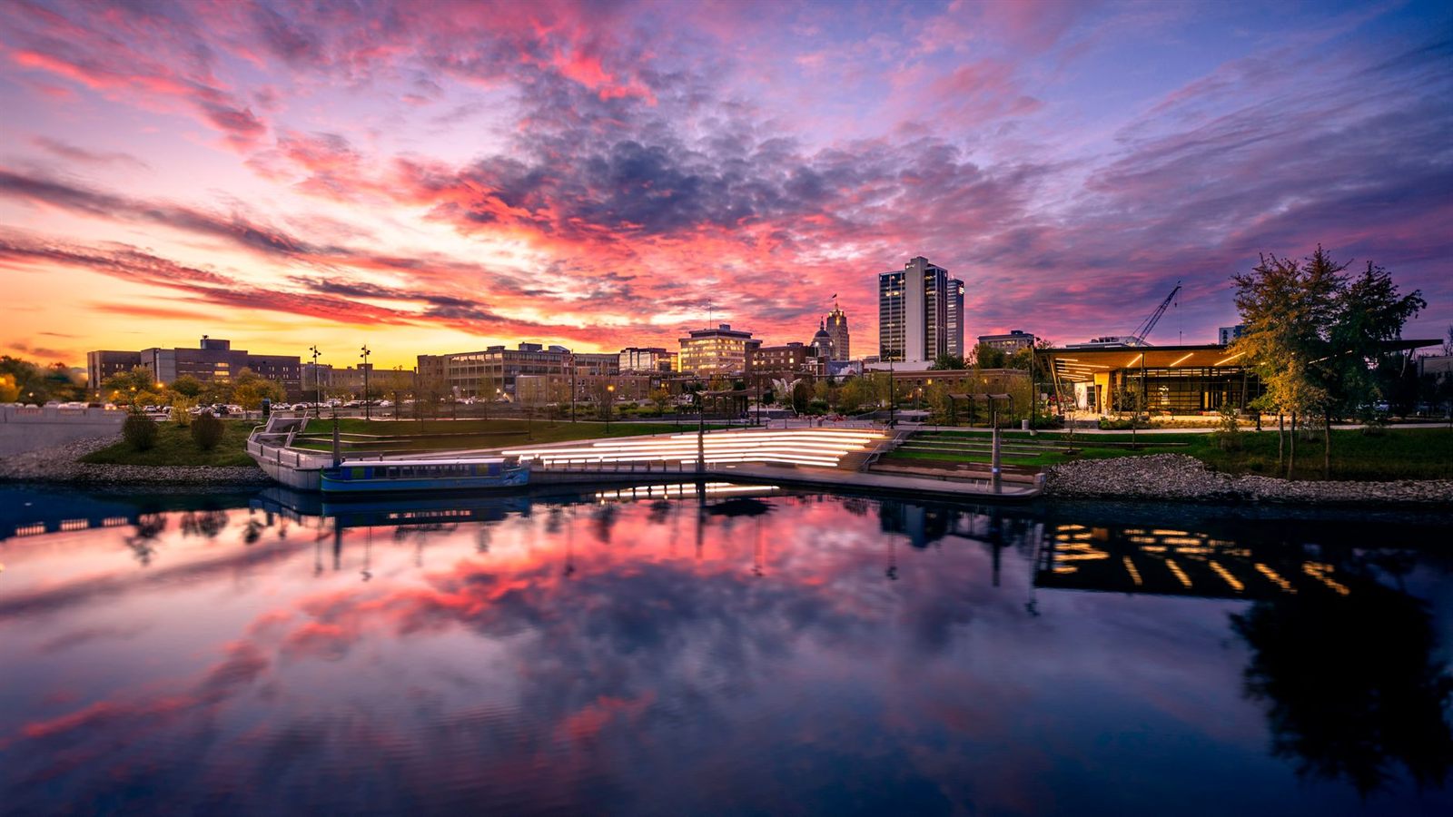 Downtown Fort Wayne, Indiana skyline at sunset over Promenade Park and the St. Marys River