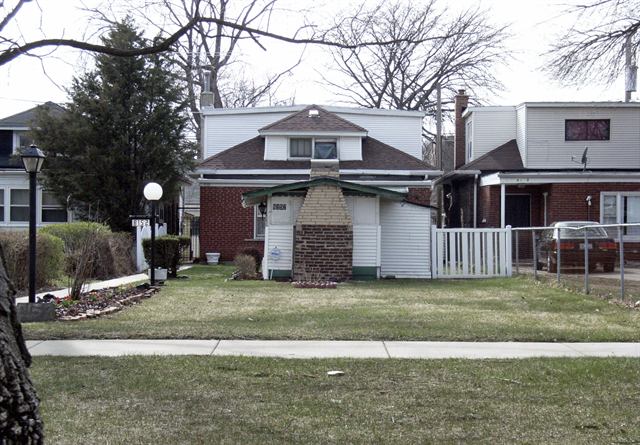 Modest brick bungalow home with a small front yard