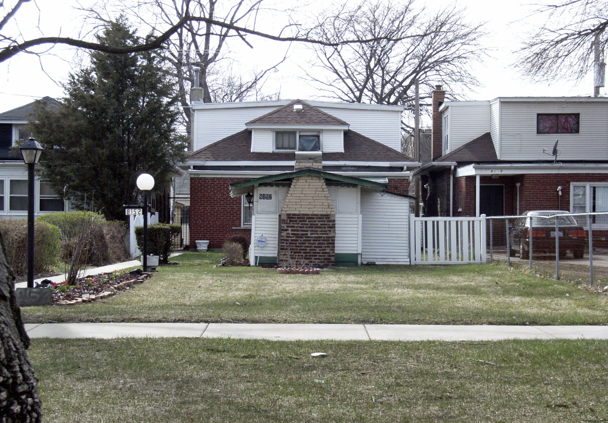 Modest brick bungalow home with a small front yard