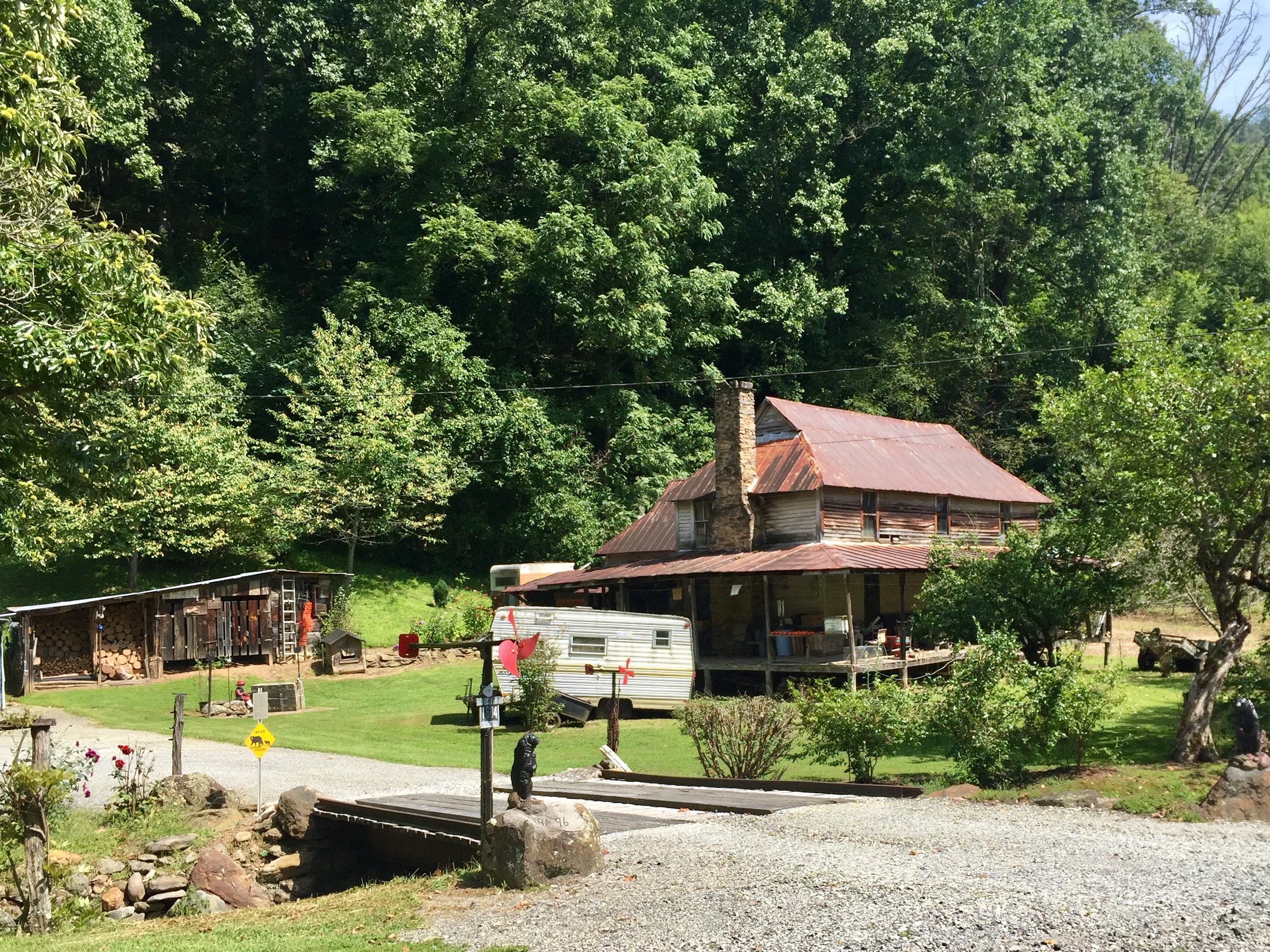Weathered old farmhouse with a rusted metal roof and full front porch