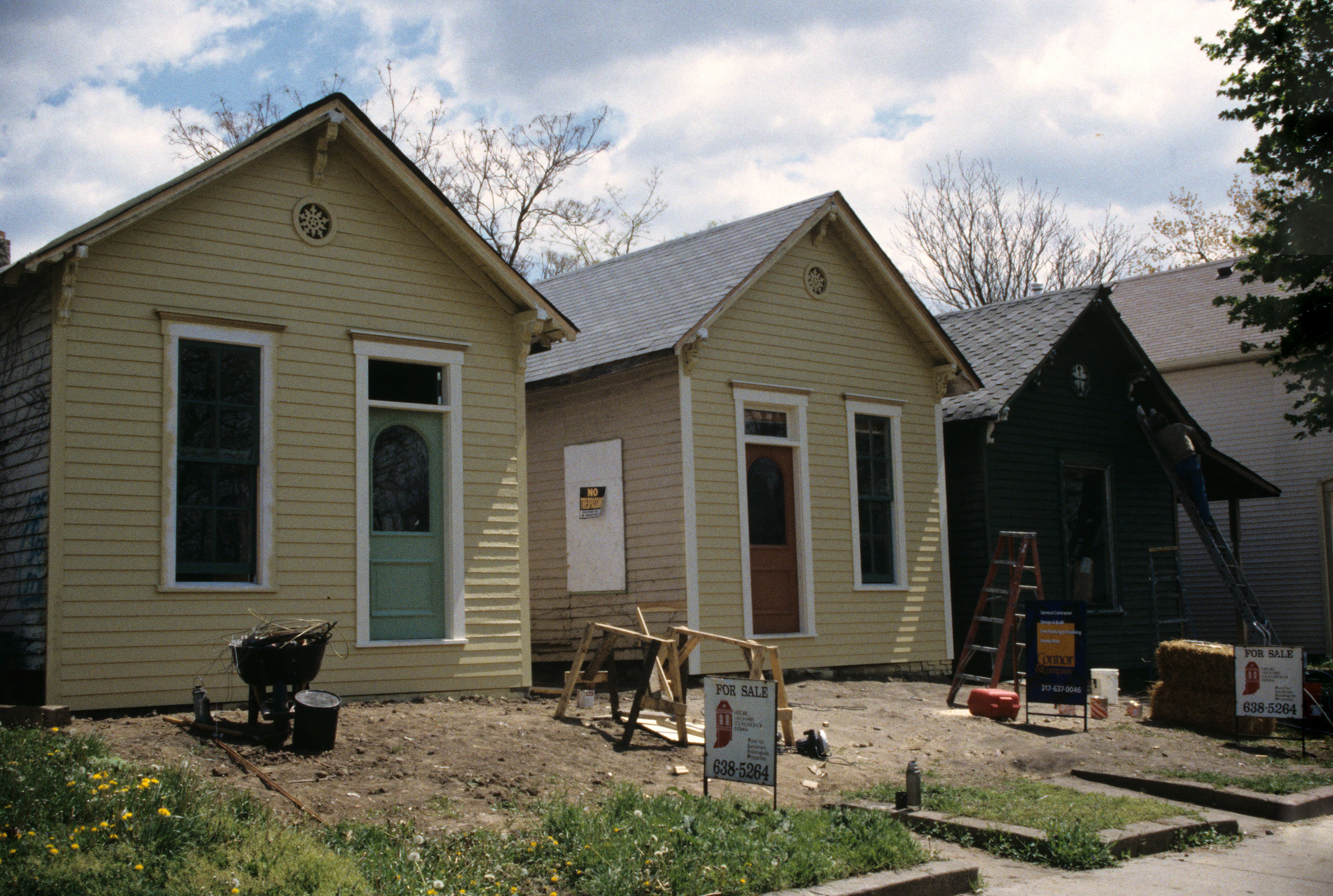 Older houses mid-renovation with for-sale signs out front