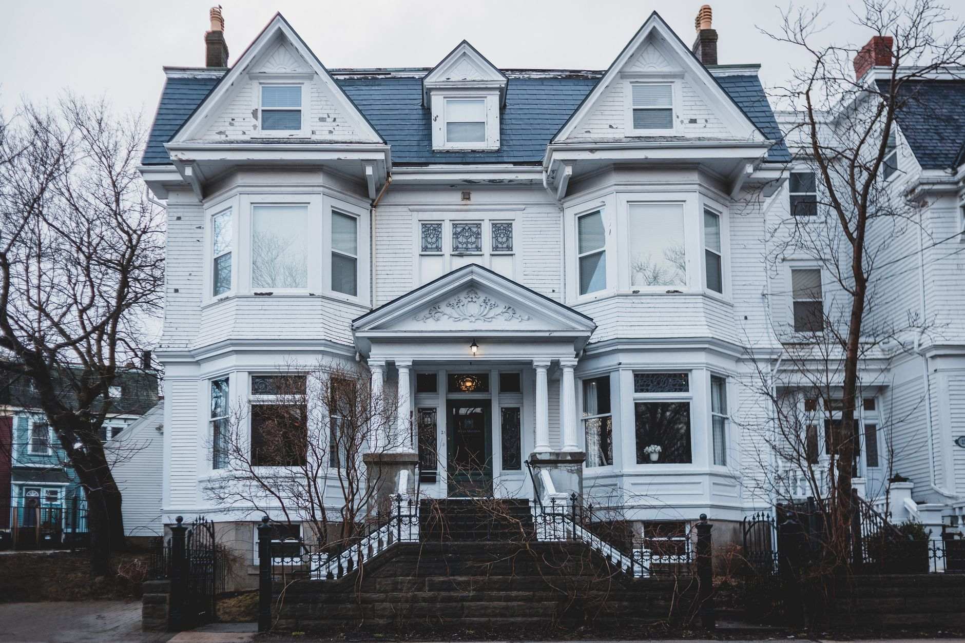 Older two-story house with peeling paint, the kind of condition that scares retail buyers but not cash buyers