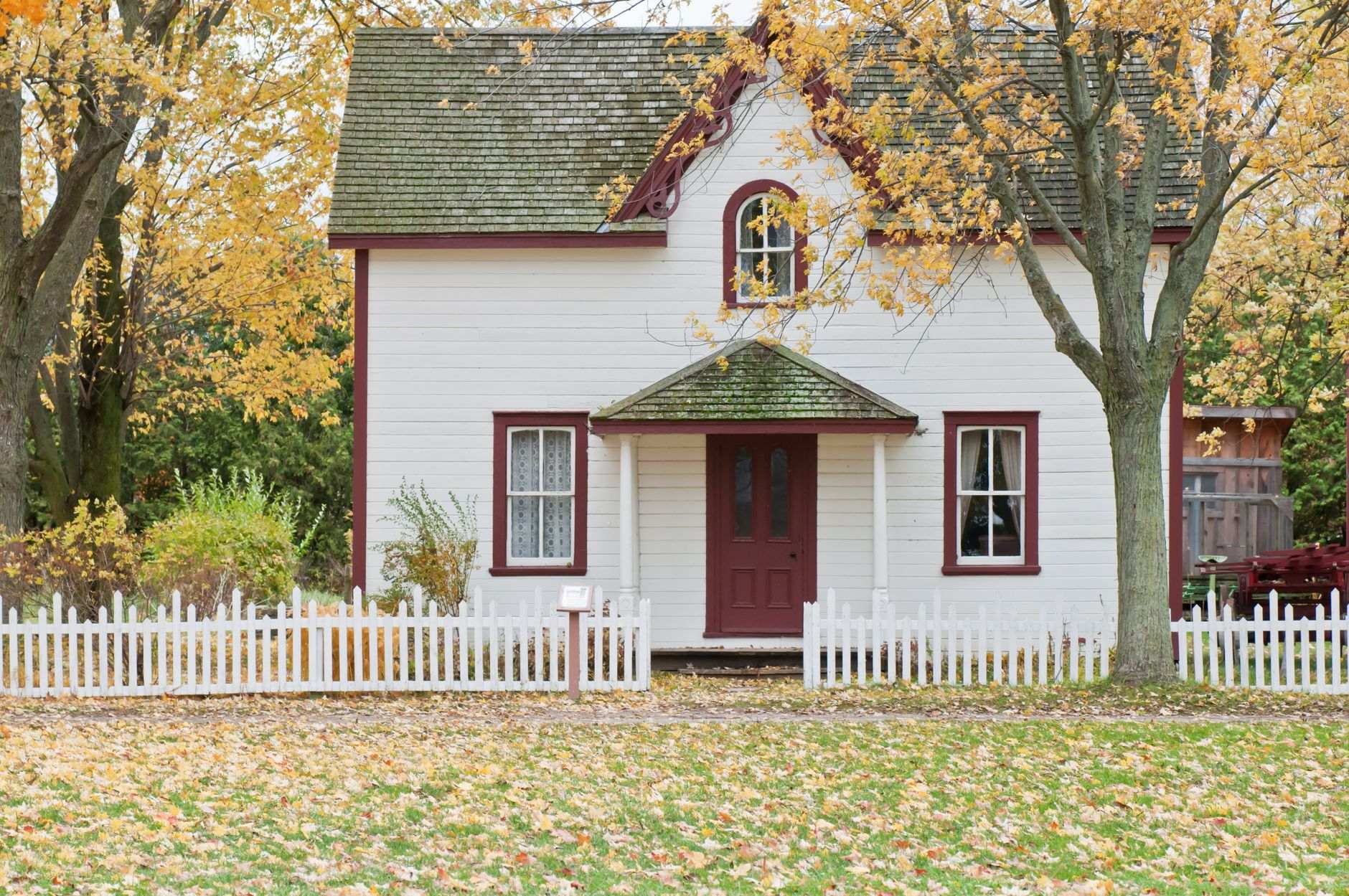White farmhouse with a picket fence in autumn, a classic Tennessee home